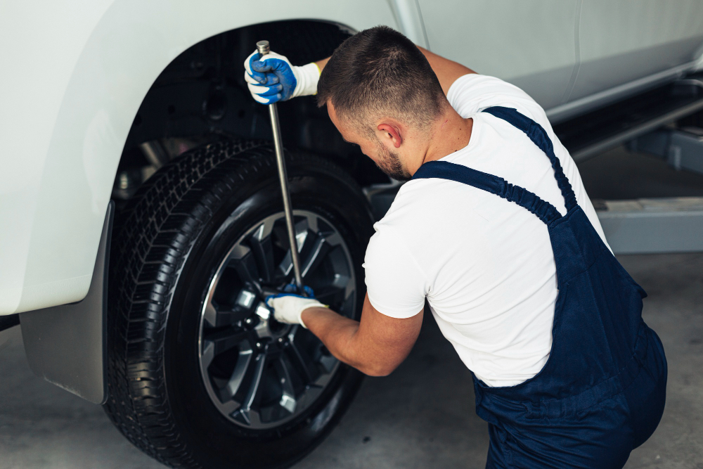 high-angle-male-mechanic-changing-car-wheels