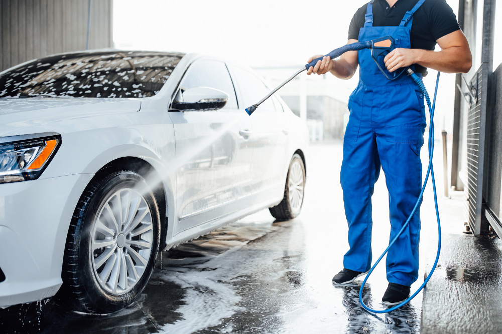 professional-washer-blue-uniform-washing-luxury-car-with-water-gun-open-air-car-wash (1)